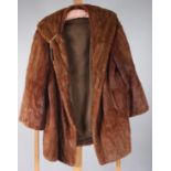 A mid brown lady's fur coat, with dark olive satin lining, length 77cm, size 10/12.