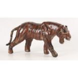 A leather model of a tiger, early 20th century, height 18cm, length 36cm.