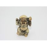 A ivory netsuke carved as a man with a mallet, early 20th century, height 4.6cm, width 2.6cm.