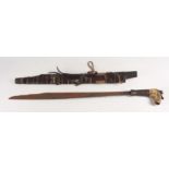 A Dayak Headhunters sword with wooden sheath decorated with carvings, hair tufts and animal hide,