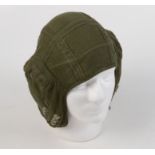 A military green cloth flying helmet, brown leather ear padding to the interior,