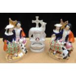 A pair of Victorian Staffordshire spill groups each with a Highland couple and a spaniel,