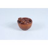 A Japanese carved wood netsuke in the form of rats in a bowl, signed, height 4cm, diameter 4.5cm.