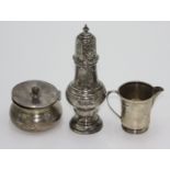 A vase shaped silver post-war sugar dredger, a silver jug and a silver powder bowl with hinged lid.