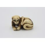 A bone netsuke carved as a dog, early 20th century, height 2cm, width 4.2cm.