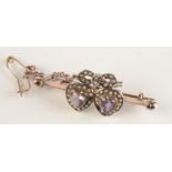 A 9ct gold bar brooch mounted with a pair of heart shaped amethysts,