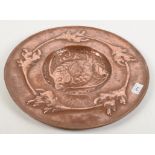 An Arts and Crafts copper wall plaque, the centre repousse decorated with a stylised fish,