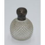A spherical cut glass perfume bottle with threaded lid.