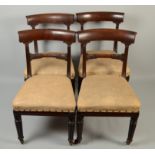 A set of four William lV mahogany dining chairs, with wide crest rails and cone fluted legs.