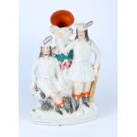 A Victorian Staffordshire still group Robin Hood with two figures, one sits above his dog,