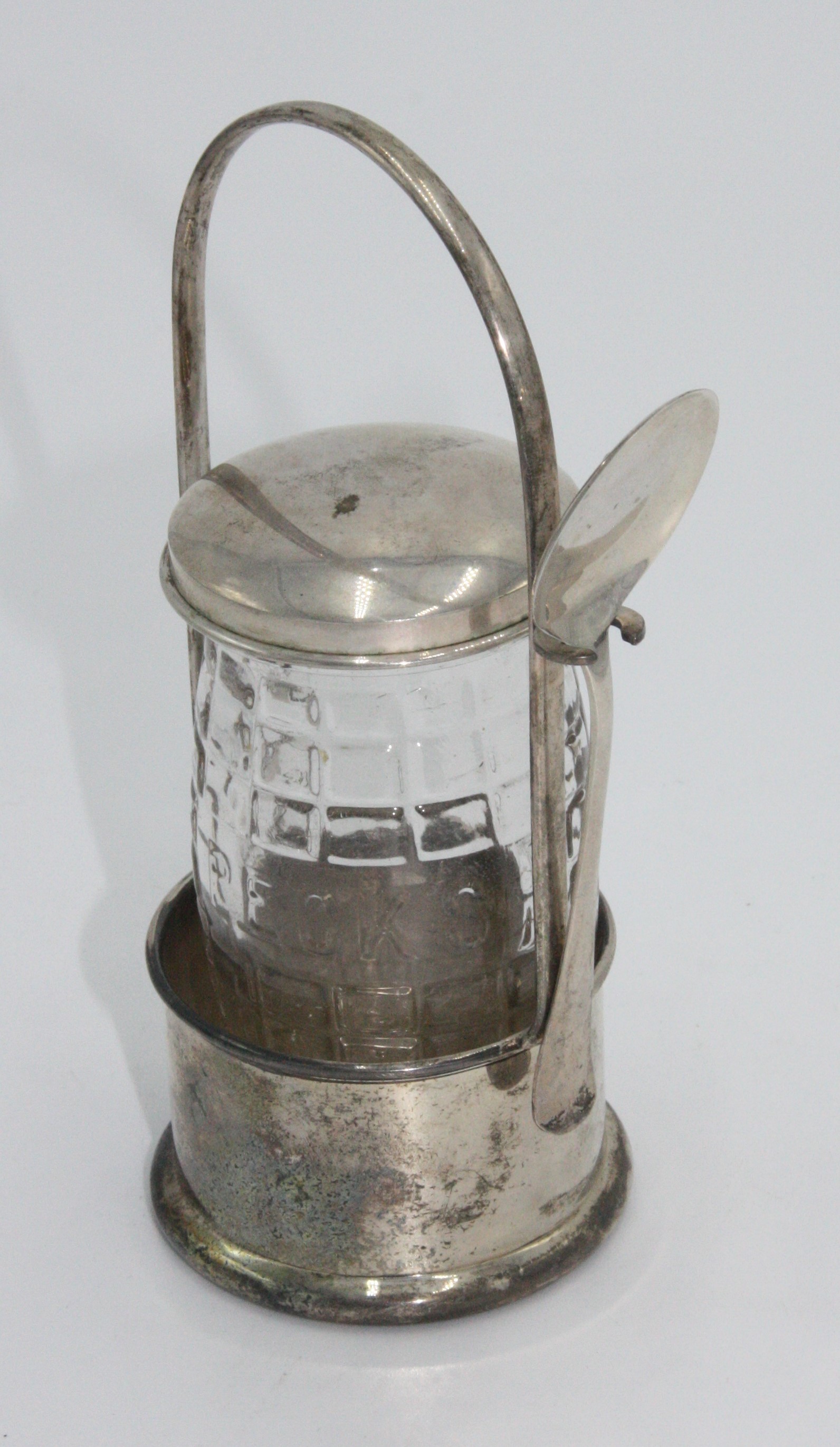 A silver bottle stand, spoon and lid (lacks bottle).