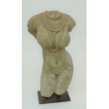 An Asian carved stone naked Bodhisattva torso wearing necklaces, a scorpion at her waist,