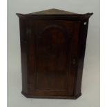 A George III oak hanging corner cupboard,