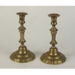 A pair of brass candlesticks, 18th century, height 25cm, diameter of base 14cm.