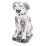 A rare 18th century tin glazed seated dog, hand painted with manganese markings,