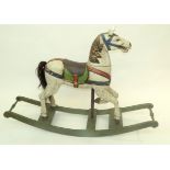 A painted carved wood rocking horse, height 85cm, length 121.5cm.