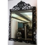 A large Victorian carved oak wall mirror, the bevelled plate within a foliate carved frame,