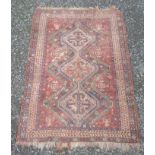 A Shiraz rug, South West Persia, the madder field with a polychrome triple linked medallion,