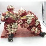 Two red painted plastic figures of Michelin men.