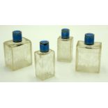 A set of four French cut glass toilet bottles with blue guilloche enamelled silver tops.