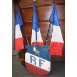 A Republic of France painted metal shield, surmounted by three flags, height 109cm.