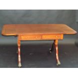 A Regency style mahogany sofa table with crossbanding and inlaid lines on twin supports with sabre