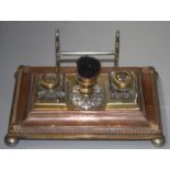 A brass and copper inkstand, 19th century, with glass inkwells, width 24.5cm, depth 16cm.