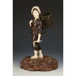 A Japanese bronze and ivory figure of a female farmer, with scythe in hand and basket on her back,
