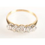 A bright 18ct gold ring set with five graduated diamonds.