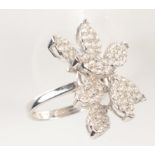 An impressive 18ct white gold and diamond ring comprising of a cluster of seven pave set leaves,