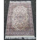 An Indian rug, the ivory field with a light brown medallion, with scrolling vines,