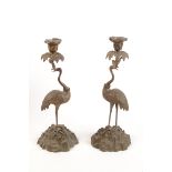 A pair of bronze candlesticks, modelled as cranes each with a crown about it's neck height 39cm.