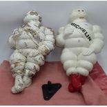 Two white painted plastic figures of Michelin men.