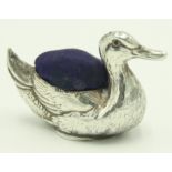 A silver pin cushion in the form of a mallard duck with ruby set eyes, Birmingham 1922.