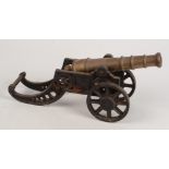 A brass model of a cannon on a cast iron carriage, total length 45cm.