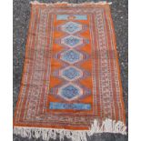 A Pakistan rug, the orange field with five linked medallions within multiple borders,