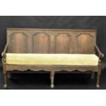 A George III oak settle, the back with four arched shielded panelled doors,