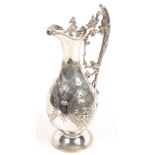 A Victorian EPNS claret jug with ornate dragon handle and pear shape body.