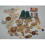 Two miniature medal groups, numerous cap badges and other military insignia.