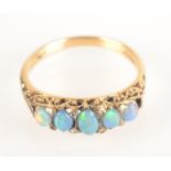 An 18ct gold ring set with five opals and tiny diamonds.