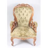 A Victorian walnut gentleman's armchair, with a padded back and seat on carved cabriole legs,