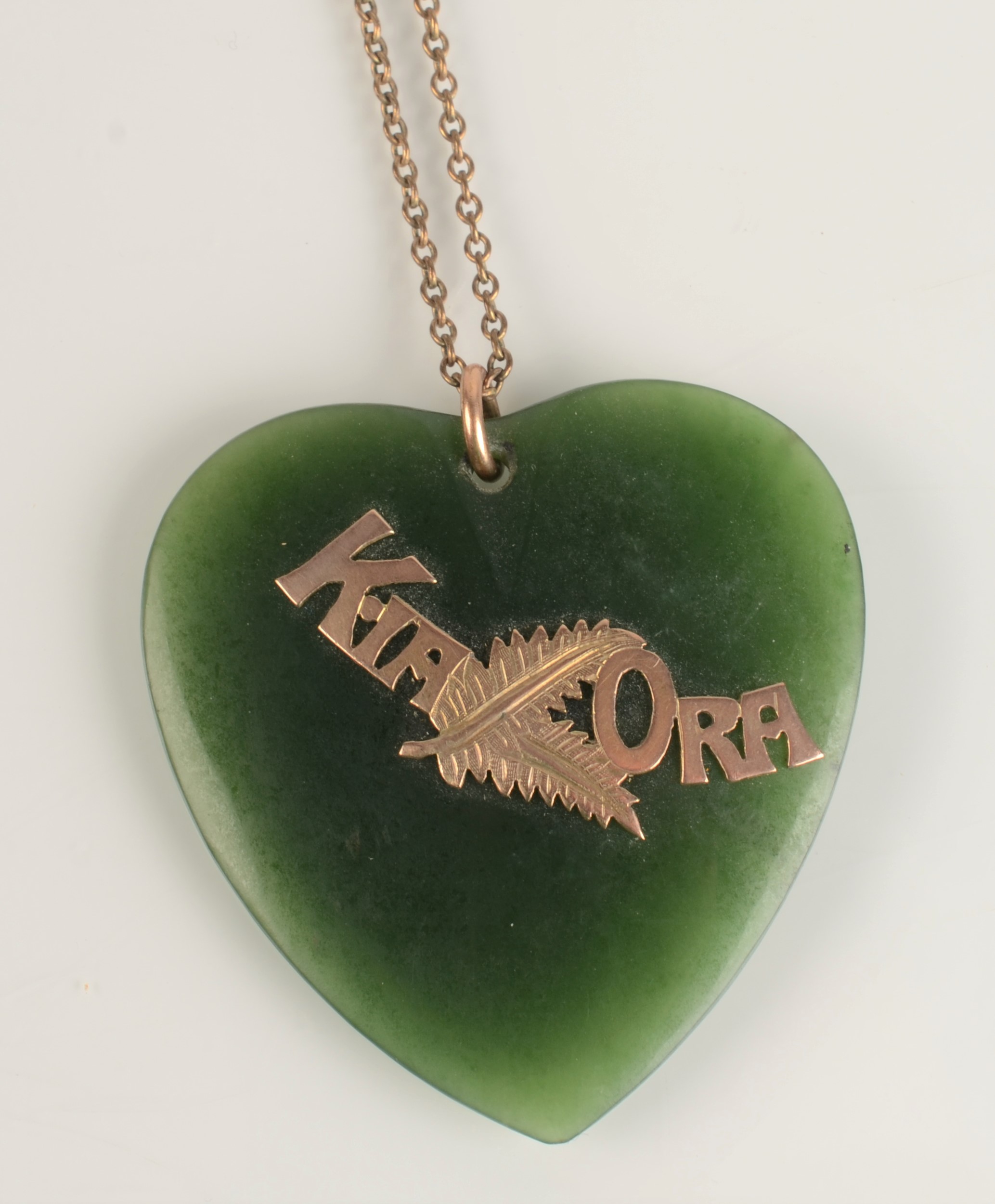 A New Zealand green stone large heart pendant with gold Kia Ora mount and on gold chain.