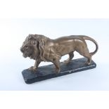 A gilt painted composition lion on a black painted base, height 24cm, length 38.5cm, width 9.7cm.