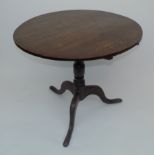 A George III oak snap top table, with tripod base and vase turned pedestal, diameter 84cm.