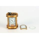 A gilt brass and porcelain oval carriage clock, the dial signed 'Elliott & Son London',