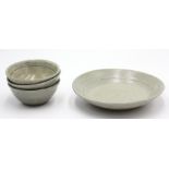 Four celadon glazed stoneware bowls, each with simple roulette decoration, unmarked.