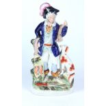 A Victorian Staffordshire figure of a huntsman, he stands holding and surrounded by game,