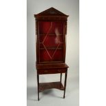 A mahogany display cabinet in Georgian style, with architectural carved pediment and glazed door,