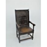 An oak wainscot armchair, the solid back carved with a central pair of pillars beneath an arch,