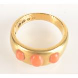 A heavy 18ct gold ring set with three cabochon red coral, 10.9g.